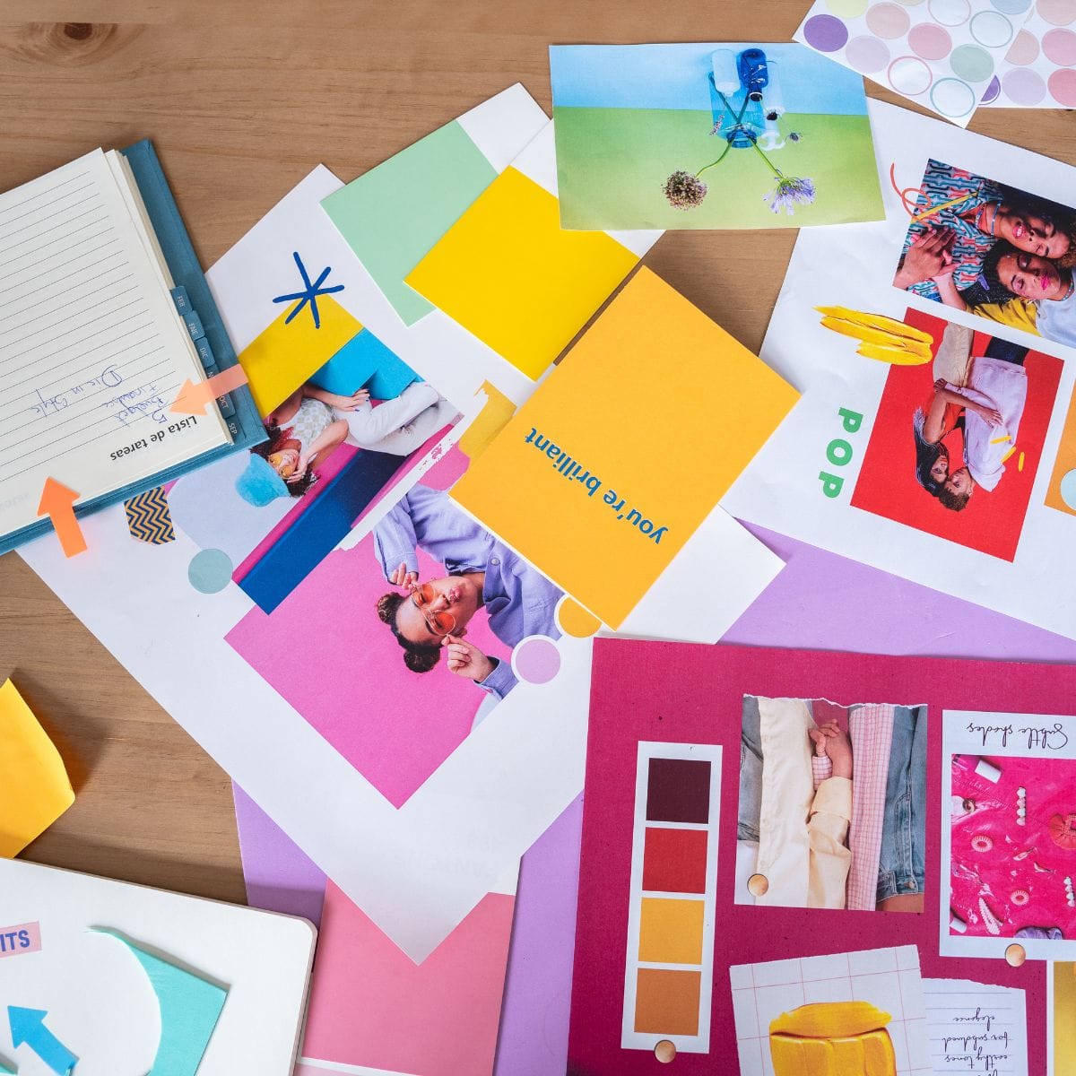 Colorful branding mood board with photos, swatches, and typography samples laid out on a wooden desk.